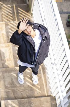 a young man is standing on the steps waving