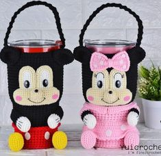 two crocheted mickey and minnie mouse mug cozies with handles on them