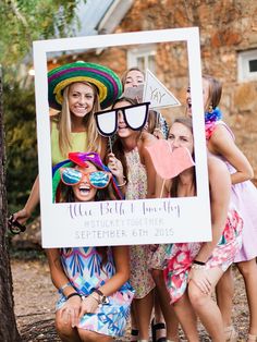 a group of people standing around each other holding up a photo booth sign that says we fell & blob party