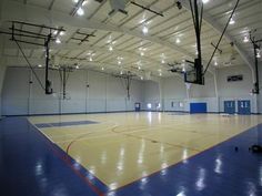 an indoor basketball court with lights on the ceiling