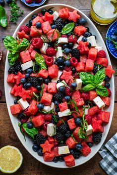 a watermelon salad with feta cheese, blueberries and raspberries