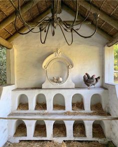 two chickens sitting on top of a white bench under a light fixture in a chicken coop