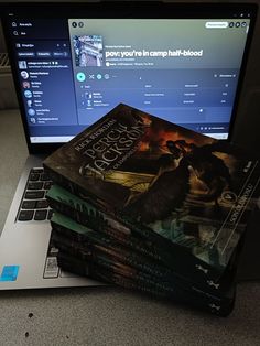 a stack of books sitting on top of a laptop computer