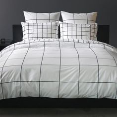 a bed with white and black checkered comforter set on top of the bed