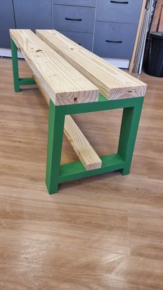 a bench made out of wood sitting on top of a hard wood floor next to drawers