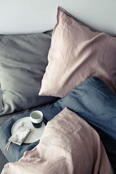 an image of a bed that has been made with linens and pillows on it