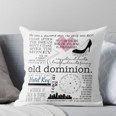 an old dominion pillow on a couch with the words written in different languages and pictures