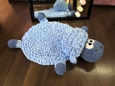 a stuffed animal is laying on the floor in front of a mirror with its eyes closed