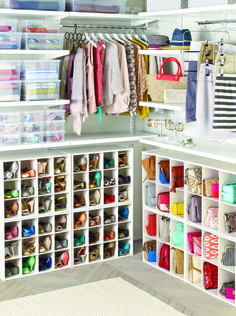 an open closet with lots of clothes and shoes on the shelves in front of it