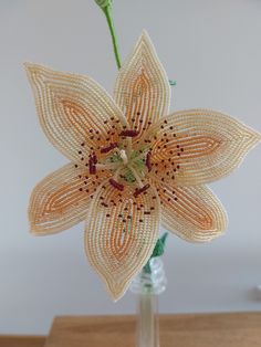 a beaded flower in a vase on a table