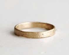 a close up of a gold ring on a white surface with no one around it