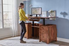 a woman standing in front of a computer desk