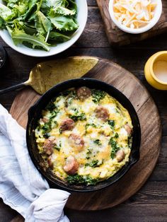 an omelet with sausage, spinach and cheese in a cast iron skillet