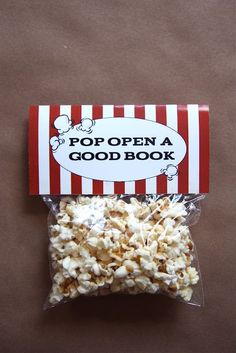 a bag of popcorn sitting on top of a brown table next to a red and white striped box