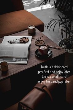 a desk with a book, coffee cup and other items on it that says truth is a debt card pay first and enjoy later