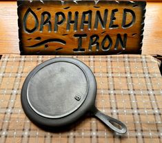 a cast iron skillet sitting on top of a table next to a wooden sign