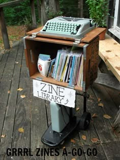 an old typewriter sitting on top of a wooden table next to a pile of books