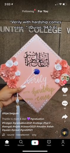 someone is holding up a pink graduation cap with flowers on it and the caption reads,