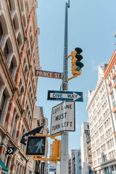 the street signs are clearly visible for everyone to see on this busy city street corner