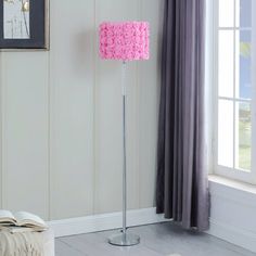 a living room with a pink lamp on the floor