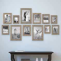 a wall with many pictures hanging on it and a table in front of the photo