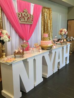 a princess birthday party with pink and gold decorations on the front, and white table cloths at the back