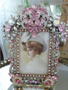 an old fashion picture frame with pink and white flowers in the center, on a table