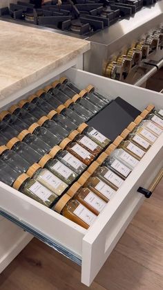 an open drawer in a kitchen filled with spices