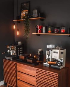 an espresso machine sitting on top of a wooden dresser next to a coffee maker