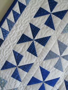 a blue and white quilt with triangles on it