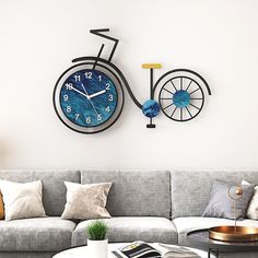 a living room with a couch, coffee table and two clocks on the wall above it