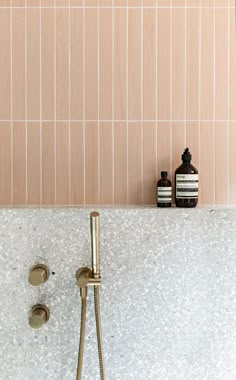 a bathtub with gold faucet and soap dispenser