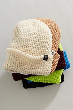 four knitted hats stacked on top of each other