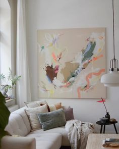 a living room filled with furniture and a painting on the wall