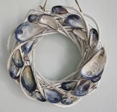 a wreath made out of seashells hanging on a wall