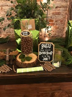 a table topped with lots of green plants and wooden slices next to a sign that says guess how much beth the peep jar?