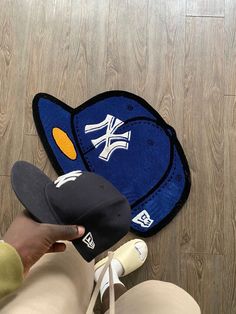 a person wearing a hat standing next to a pair of baseball caps on the floor