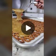 a person is pouring caramel sauce on pretzels