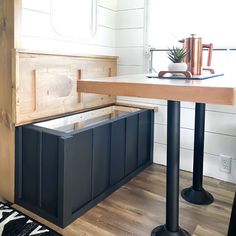 a kitchen area with a table, stools and an open storage box on the floor