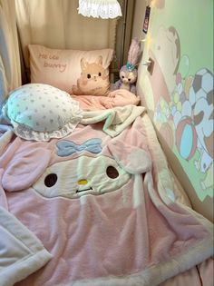 two stuffed animals sitting on top of a bed next to pillows and blankets in a child's room