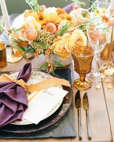 the table is set with flowers and place settings