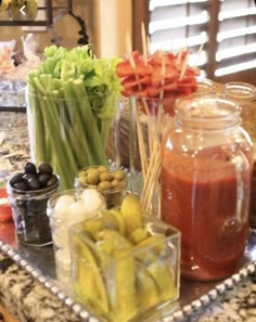 several jars filled with different types of food on a counter top next to an assortment of fruits and vegetables