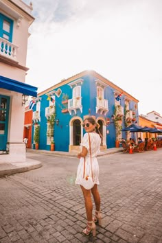 a woman standing in front of a blue building