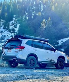 a white suv parked on the side of a mountain