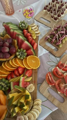 there are many different fruits and vegetables on the trays with skewered toothpicks