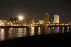 the city is lit up at night by the water