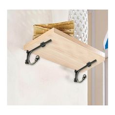 a wooden shelf with two hooks on it