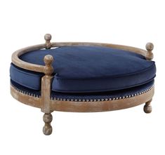 a round wooden ottoman with blue cushion on it's back end and legs,