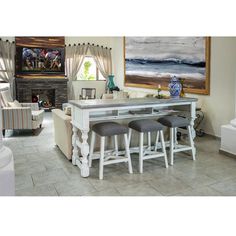 a dining room table with four stools and a painting on the wall behind it