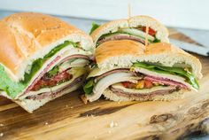 a cut in half sandwich sitting on top of a wooden cutting board